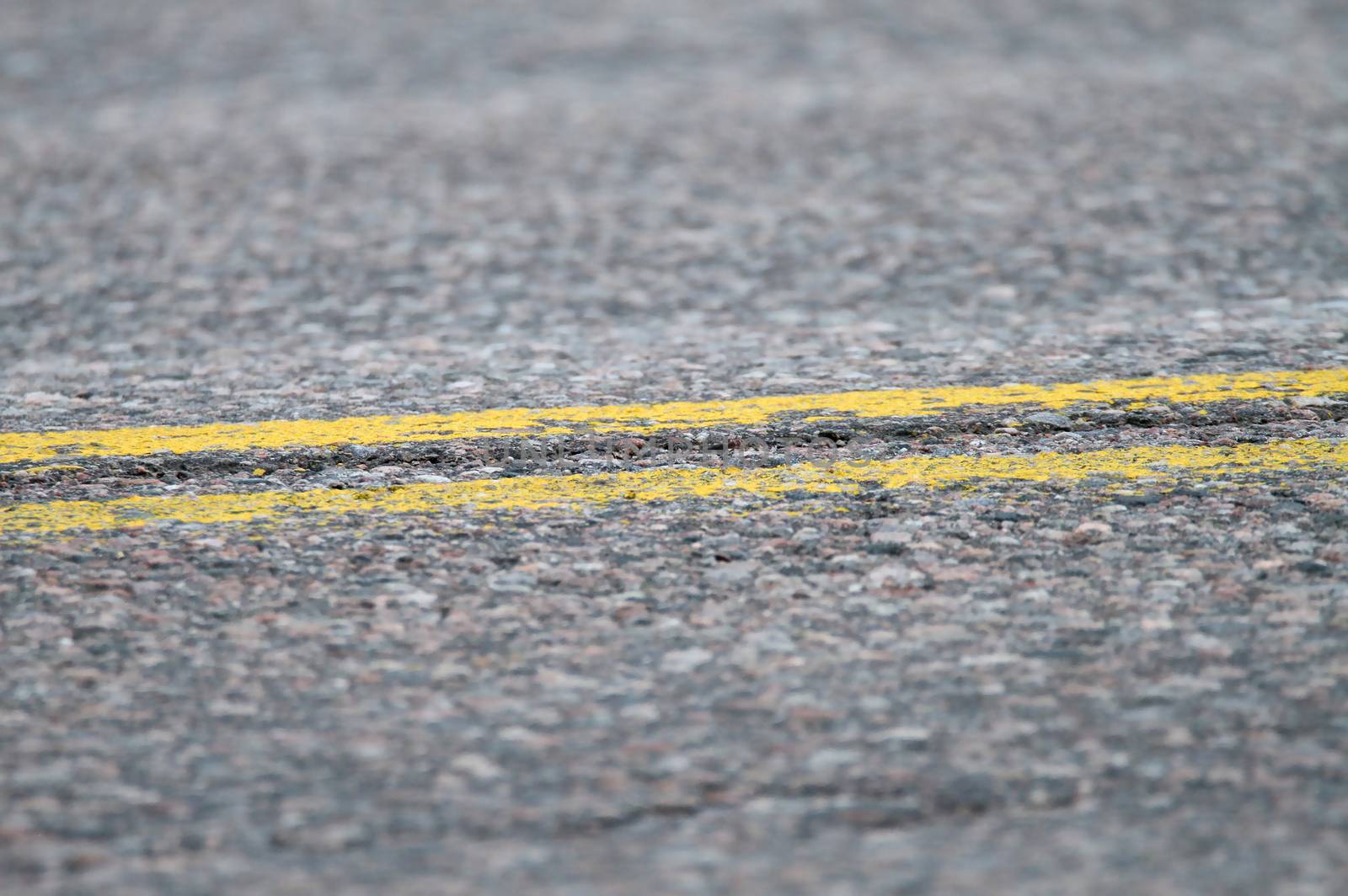 Yellow lines on tarmac at the center of the highway.