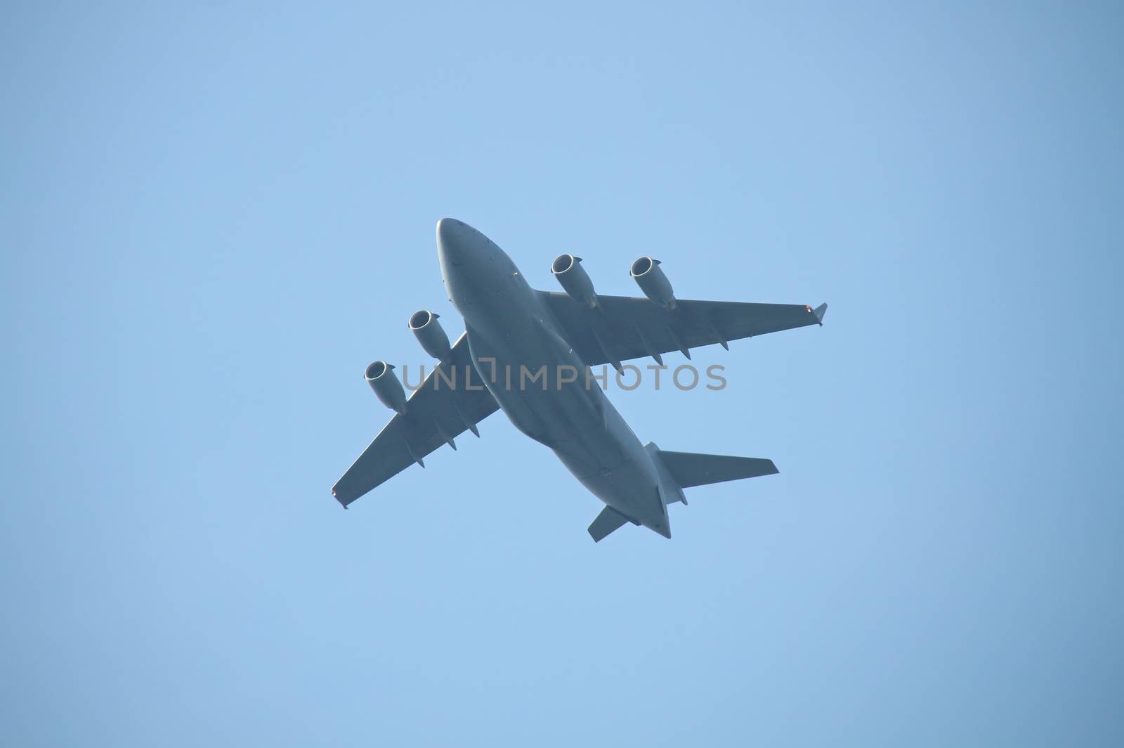Military cargo plane flying over by Valokuva24
