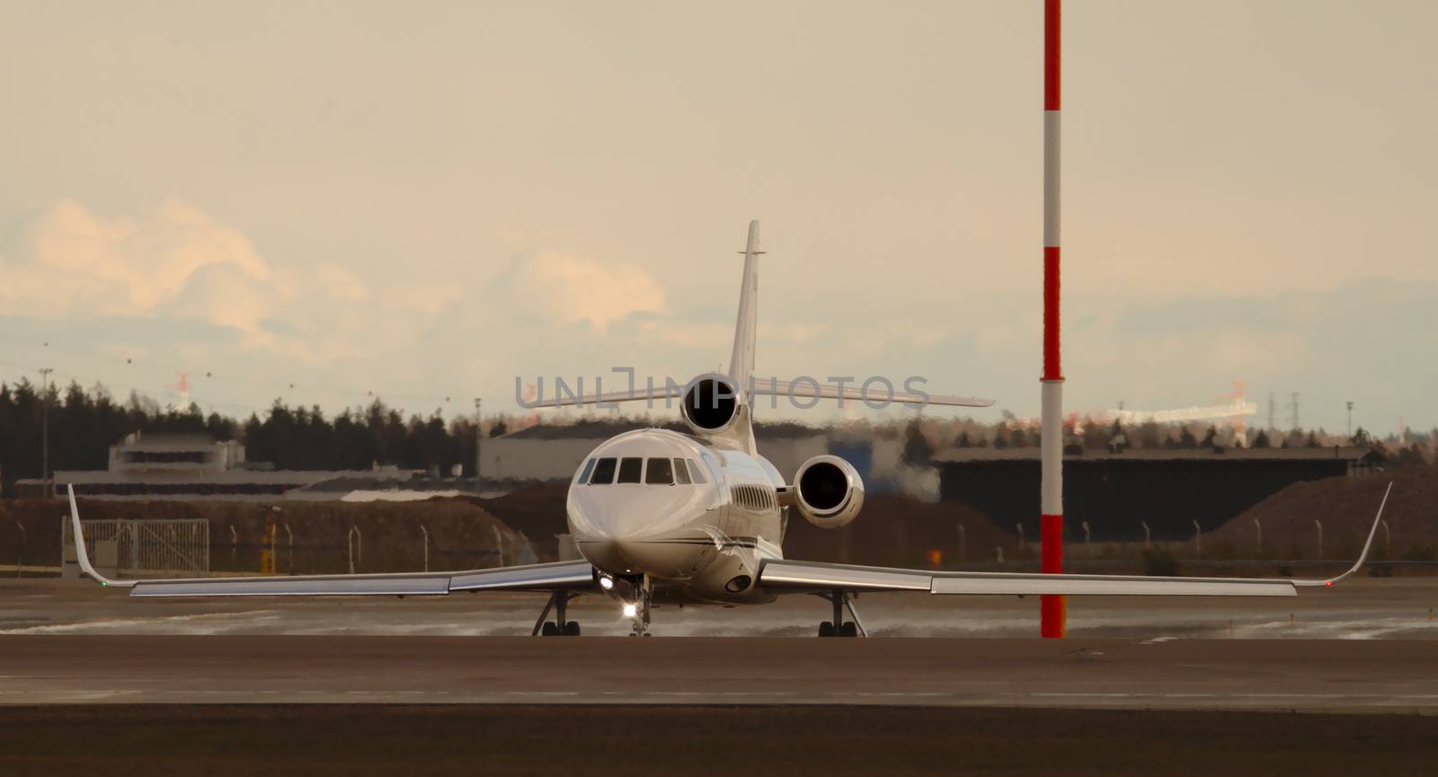 White private jet waiting in takeoff line in the evening just before sunset. by Valokuva24