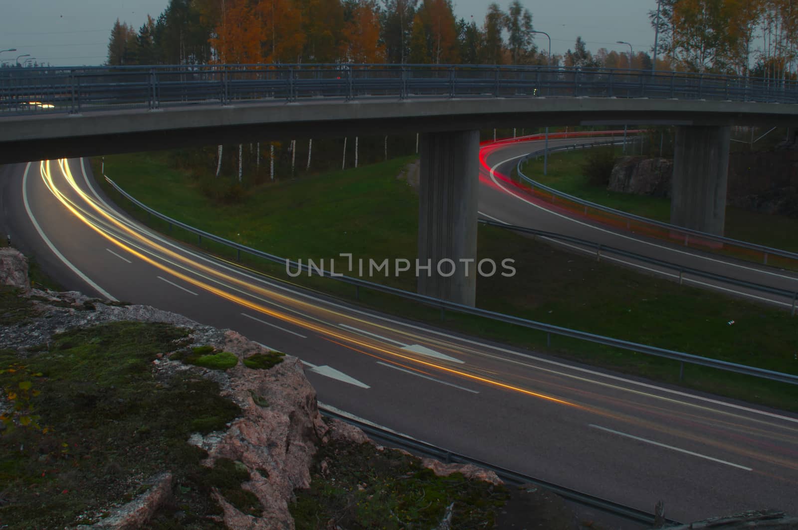 Light trails of passing cars in twilight by Valokuva24