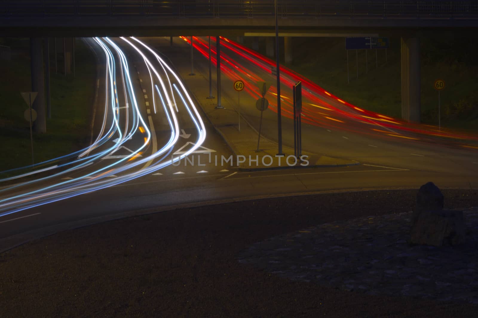 Light trails of headlights and taillights of cars at rush hour on the road. by Valokuva24