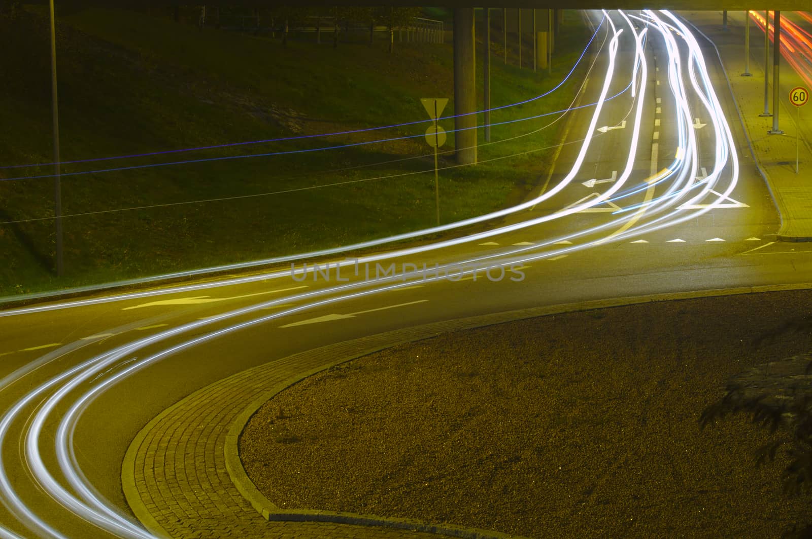 Light trails of headlights of cars entering the circle.