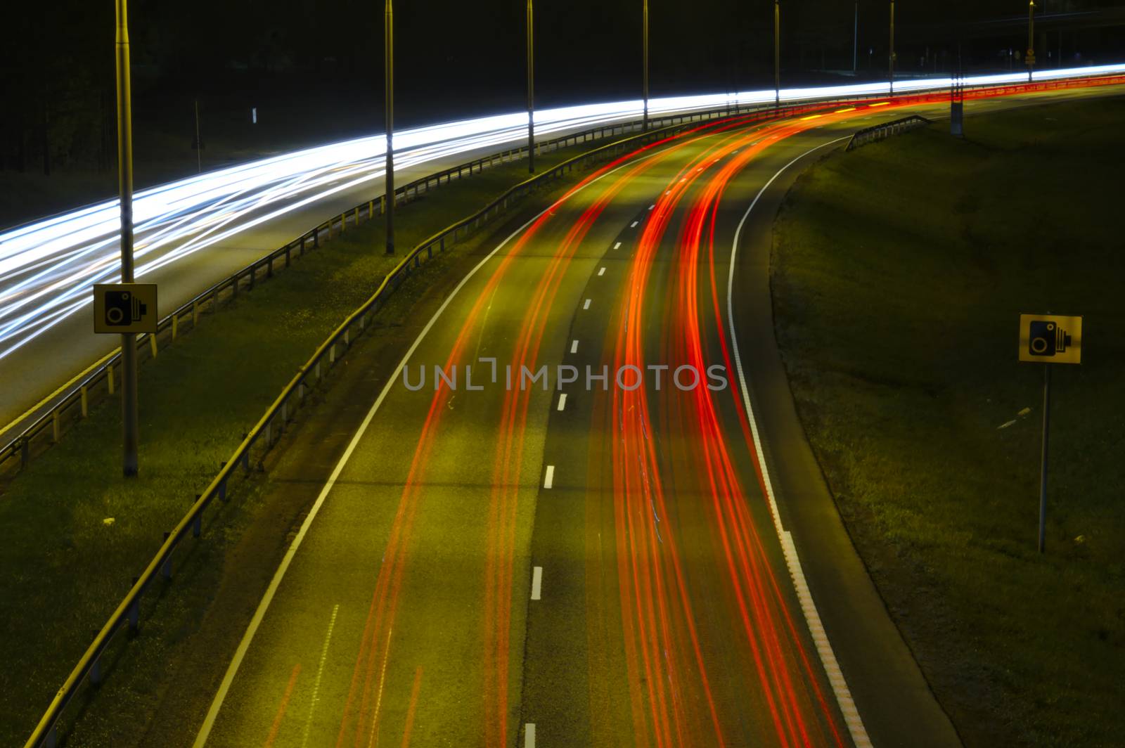 Night traffic on a highway. Passing cars leaving light trails