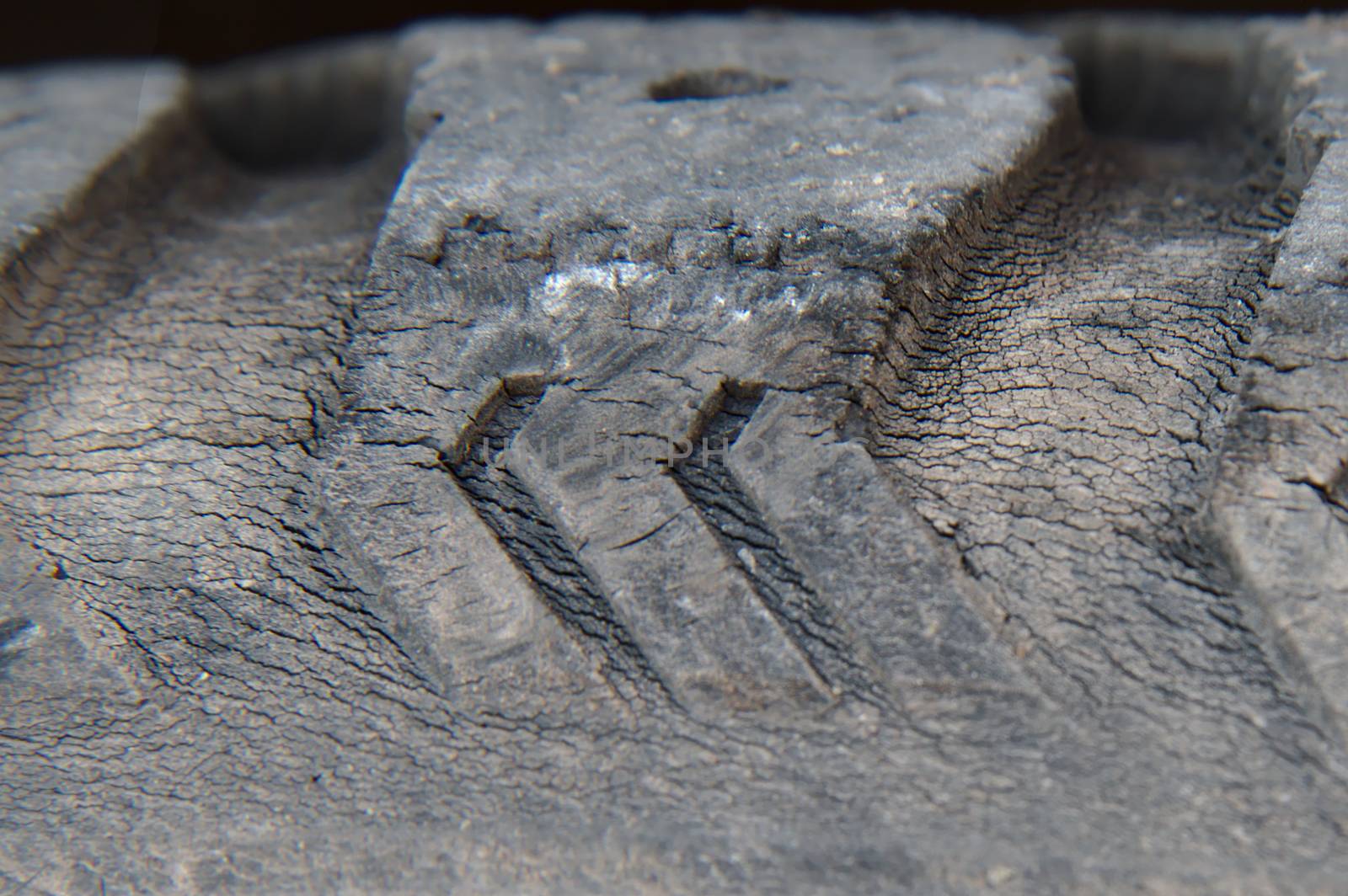 Cracked surface of an old tire of a car. Even rubber will eventually break.