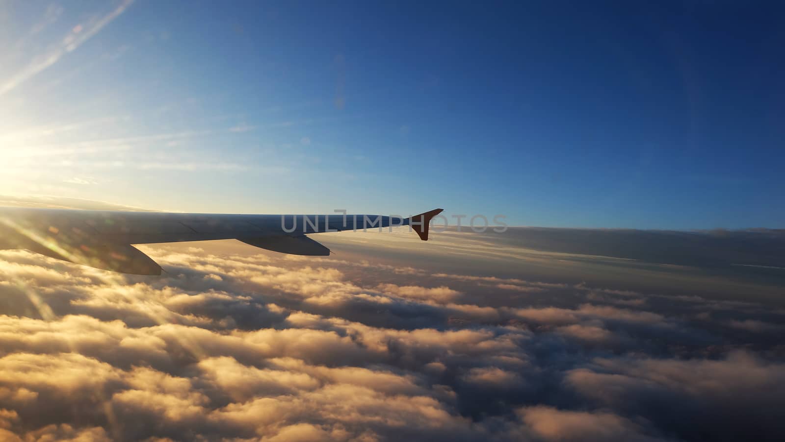 wing of a Airplane at sunset with clouds. Travel, adventure, transport concept. View from the wing window at sunset.