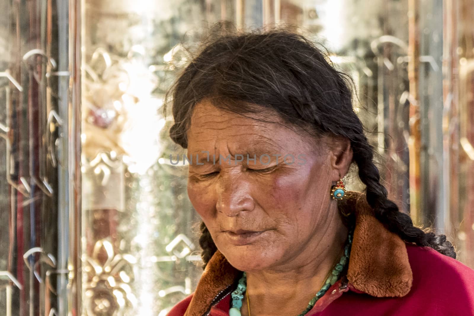 A old buddhist in Lharong Monastery and the Monk houseson surrounded in Sertar, Tibet.  Lharong Monastery is a Tibetan Buddhist Institute at an elevation of about 4300 meters.