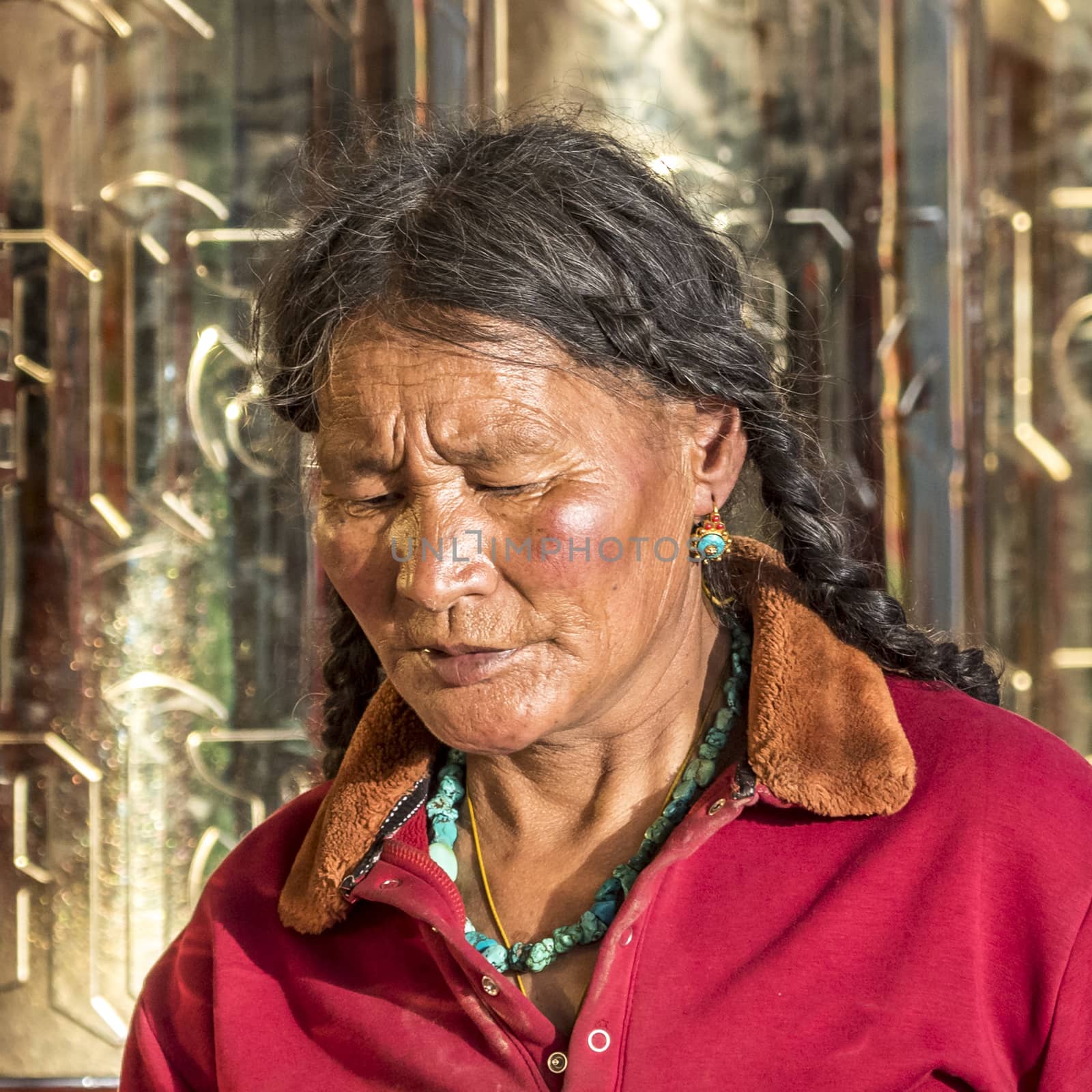 A old buddhist in Lharong Monastery and the Monk houseson surrounded in Sertar, Tibet.  Lharong Monastery is a Tibetan Buddhist Institute at an elevation of about 4300 meters.