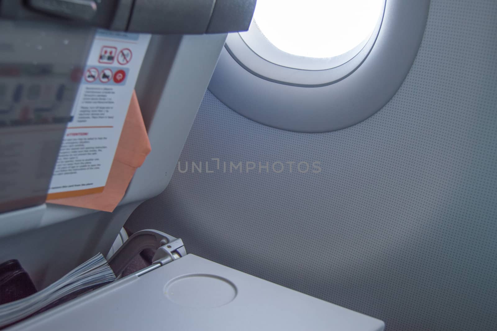 Folding table, flight instructions, magazine in the front seat, porthole, concept of flights and travel by claire_lucia