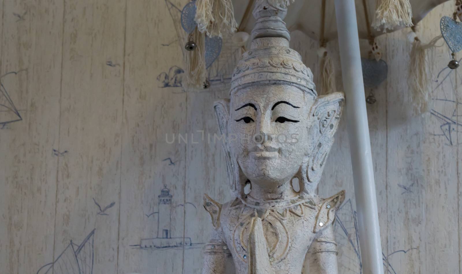 white buddha statue under a umbrella in closeup, a spiritual or buddhist background