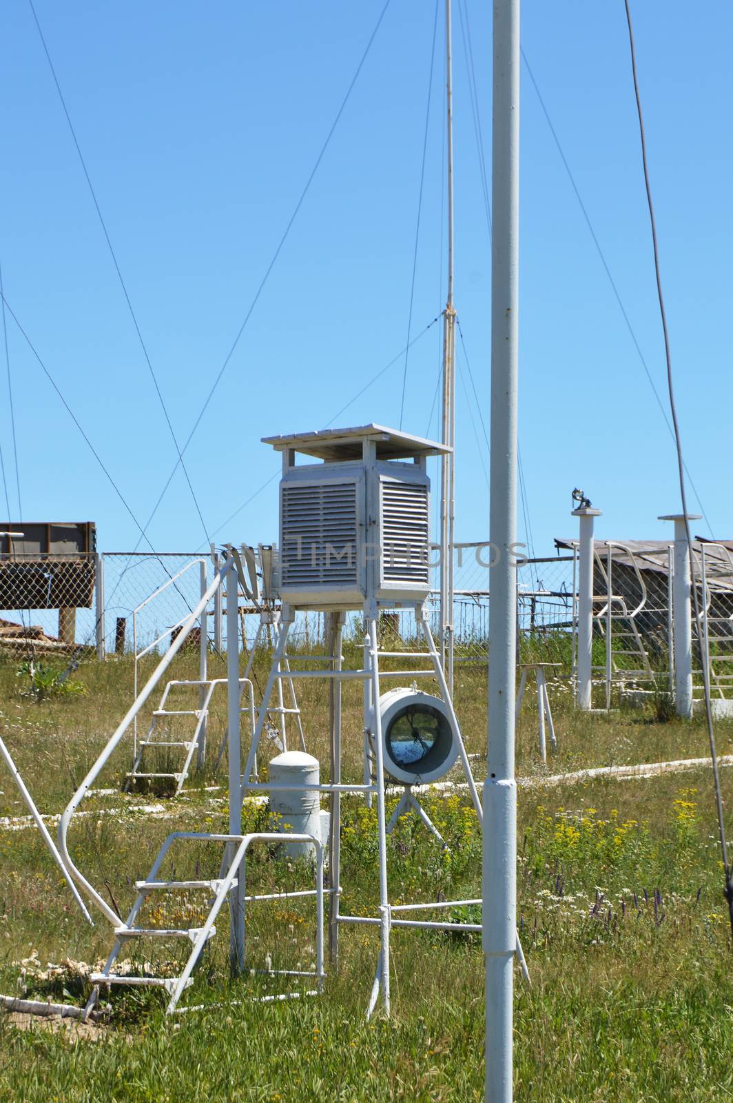 Weather station at the top of the mountain against the blue sky and grass on a Sunny summer day, vertical shot.