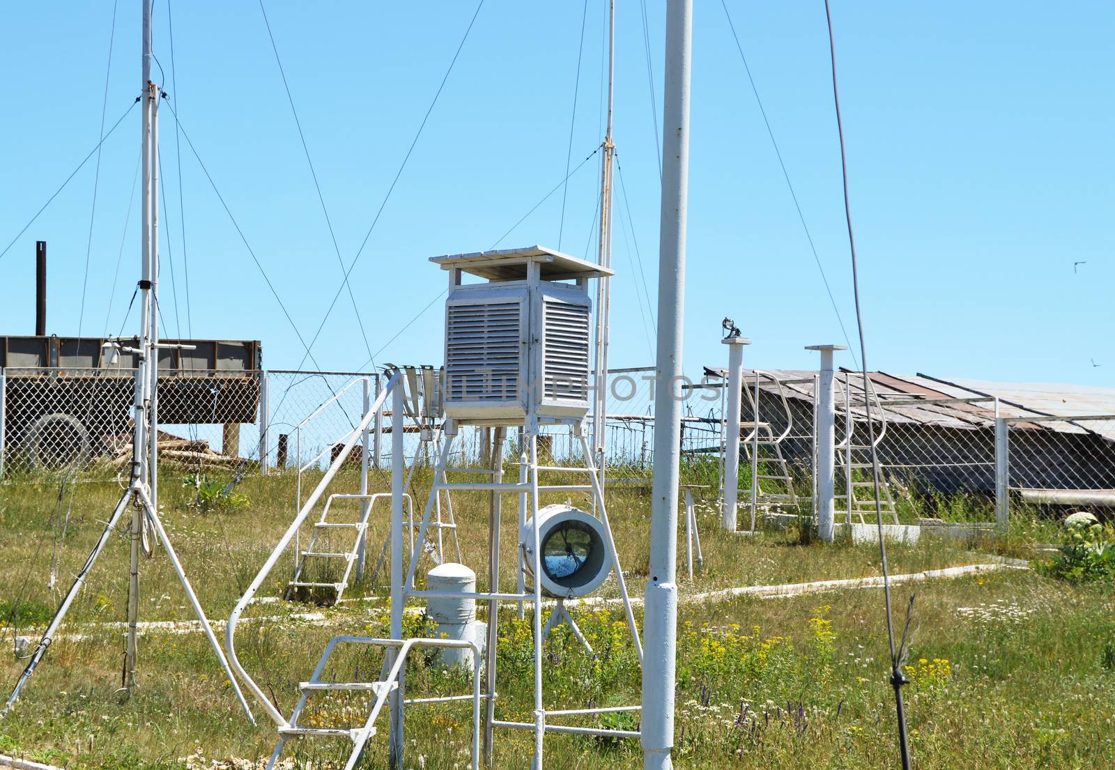 Weather station at the top of the mountain against the blue sky and grass on a Sunny summer day.