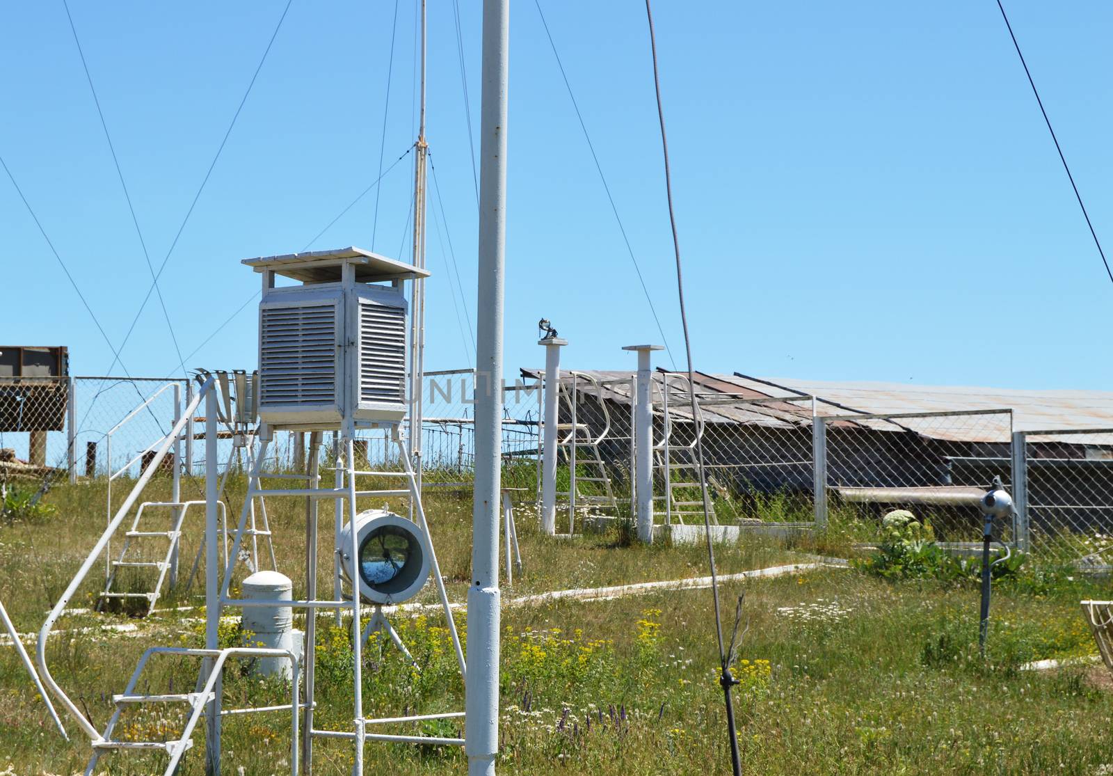 Weather station at the top of the mountain against the blue sky and grass on a Sunny summer day.