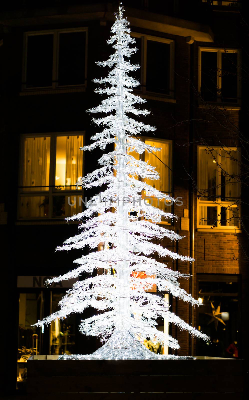lighted up christmas tree decoration in the city streets at night