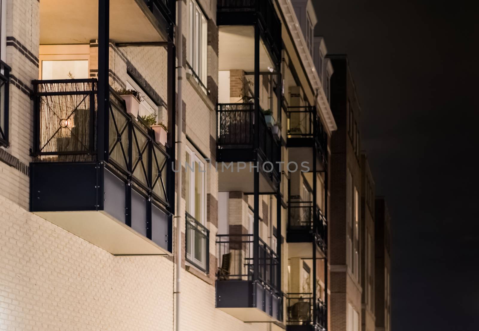 Modern apartment balcony's with metal frameworks in closeup at night, dutch architecture background by charlottebleijenberg