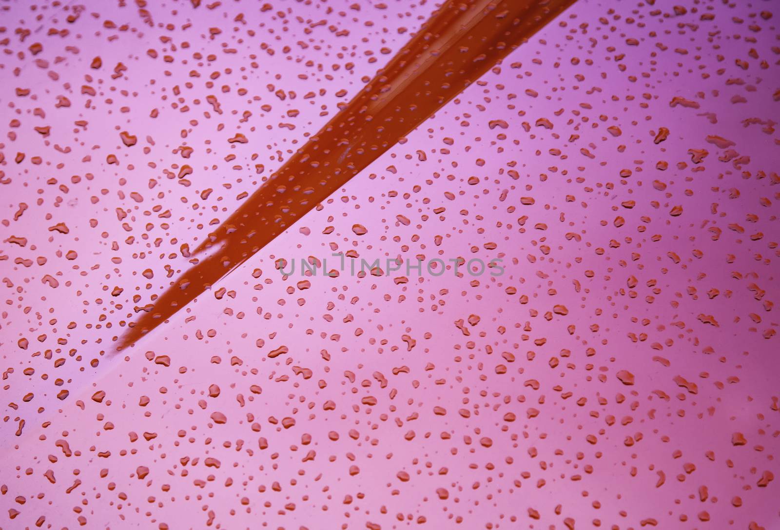 Drops of water on a red metal, detail of rain and cold in winter