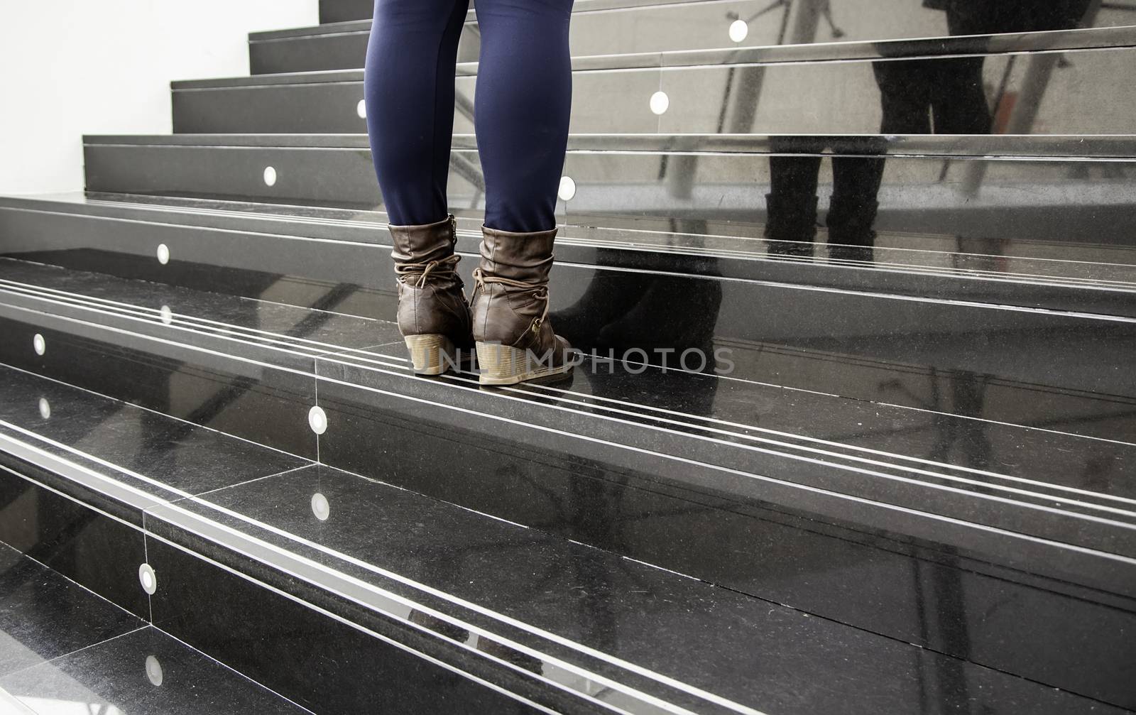 Women's boots on a staircase, fashion detail and present