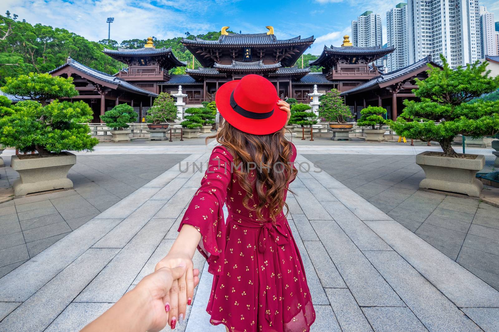 Women tourists holding man's hand and leading him to Chi Lin Nunnery temple, Hong Kong. by gutarphotoghaphy
