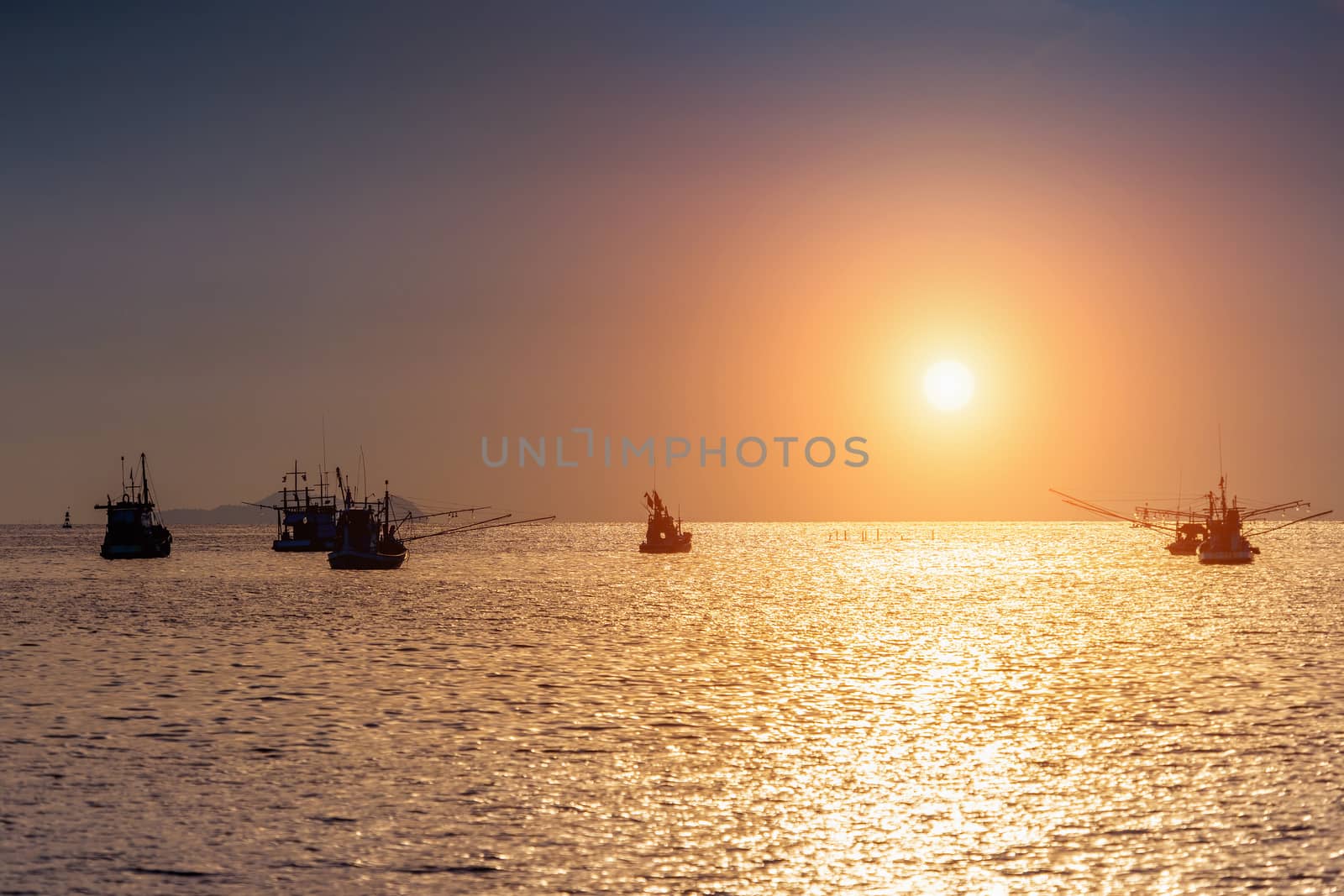 Beautiful sunset at ocean with silhouette of fishing boat. by gutarphotoghaphy