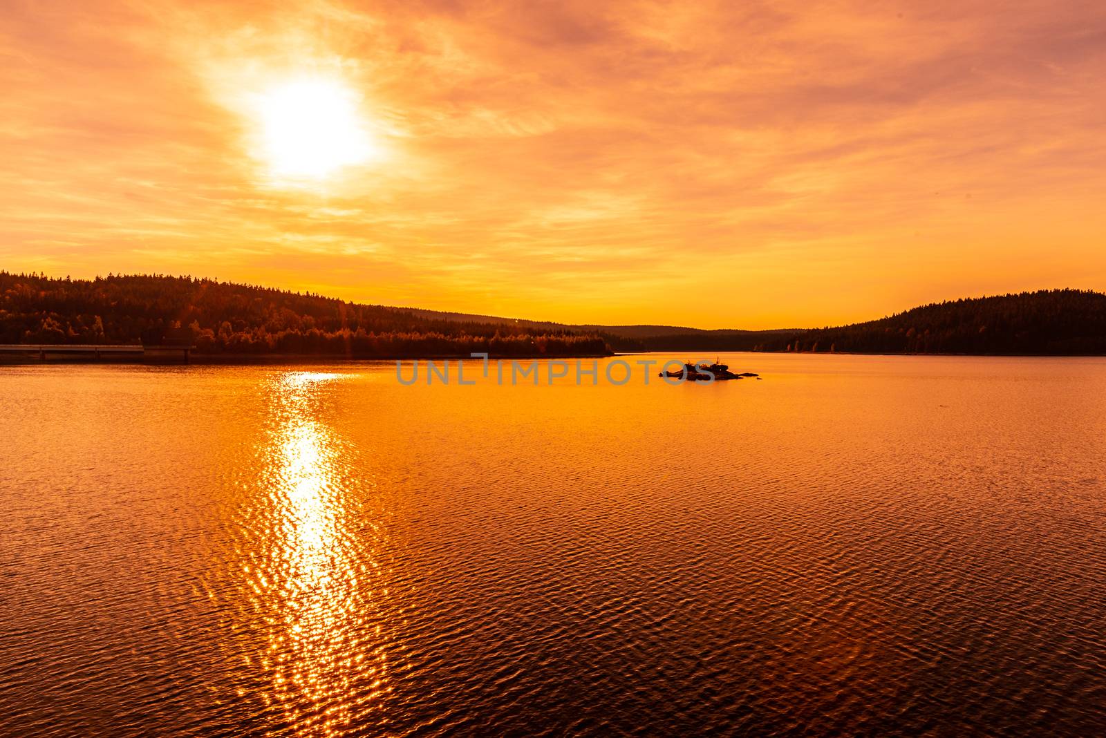 Sunset reflected in water. Josefuv Dul Dam, Jizera Mountains, Czech Republic by pyty