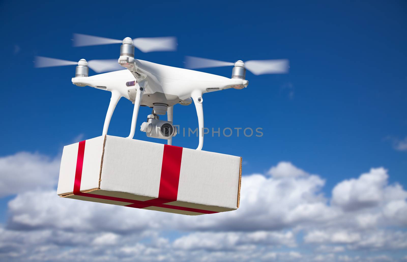 Unmanned Aircraft System (UAV) Quadcopter Drone Delivering Box With Red Ribbon by Feverpitched