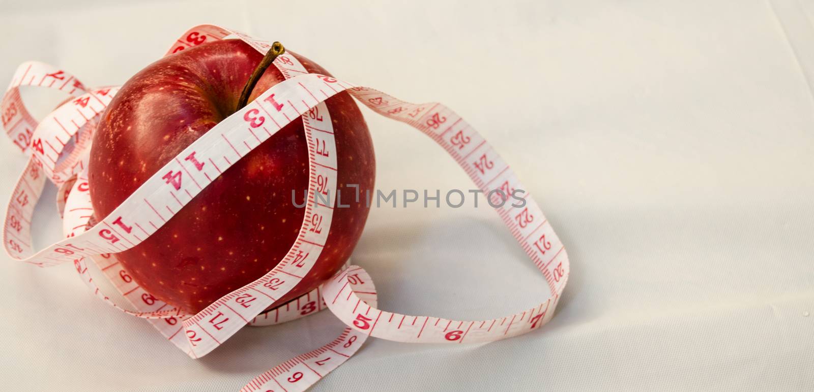 red apple with measurig tape, weigh loss concept, white background