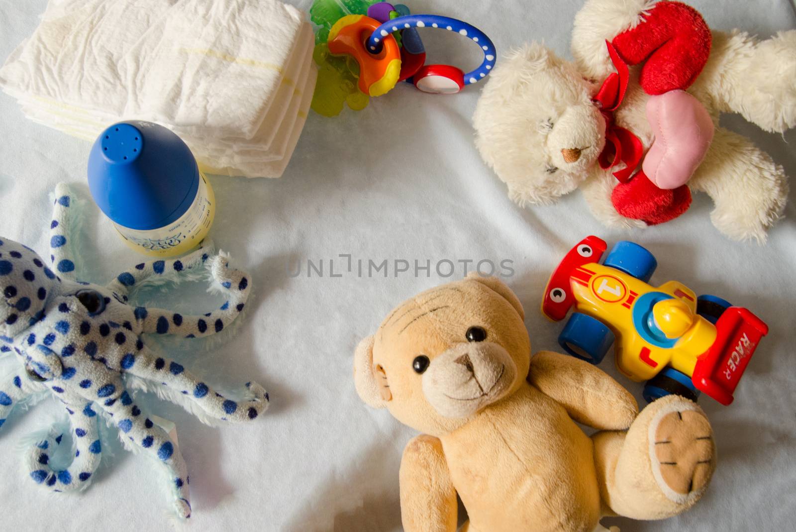 flat lay of baby stuff, diapers, octopus, teddy bear, teething toys