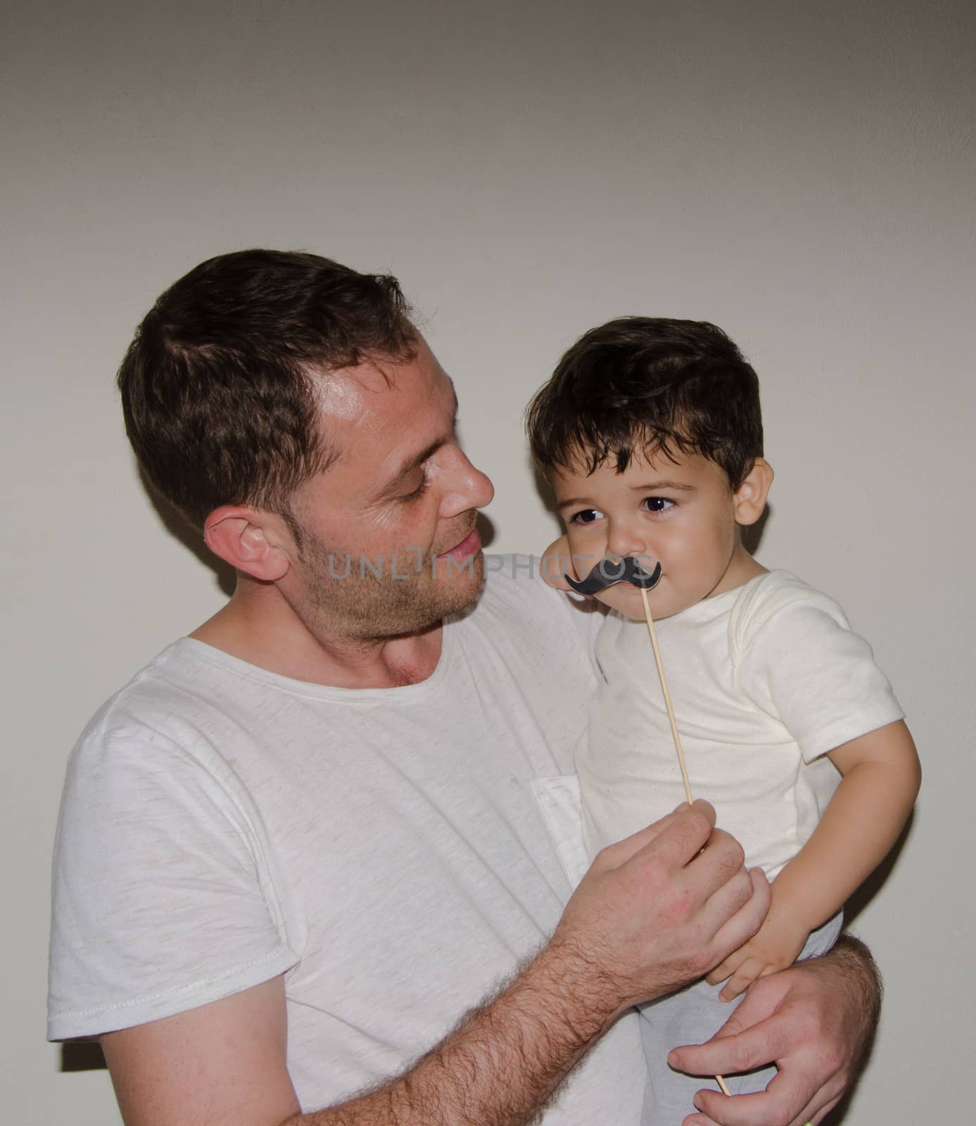 Father and son playng with moustache funny faces by negmardesign