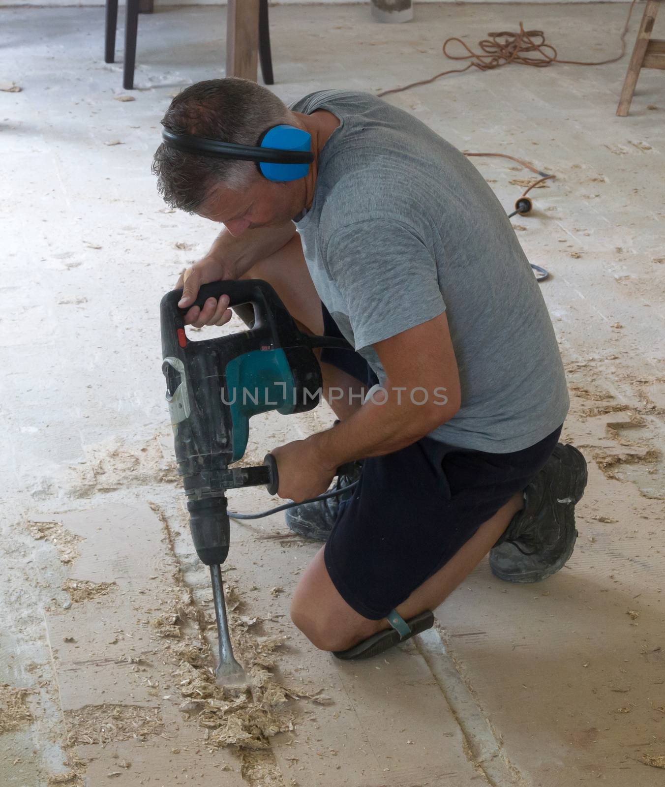 Construction concept - Jackhammer, removing chipboard from the floor - Selective focus