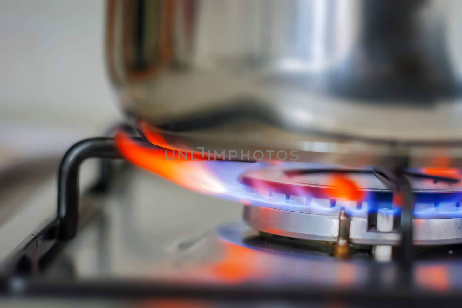 Blue glowing flame burning from the kitchen cooker. Gas and fire. Cooking concept. Interior domestic shot