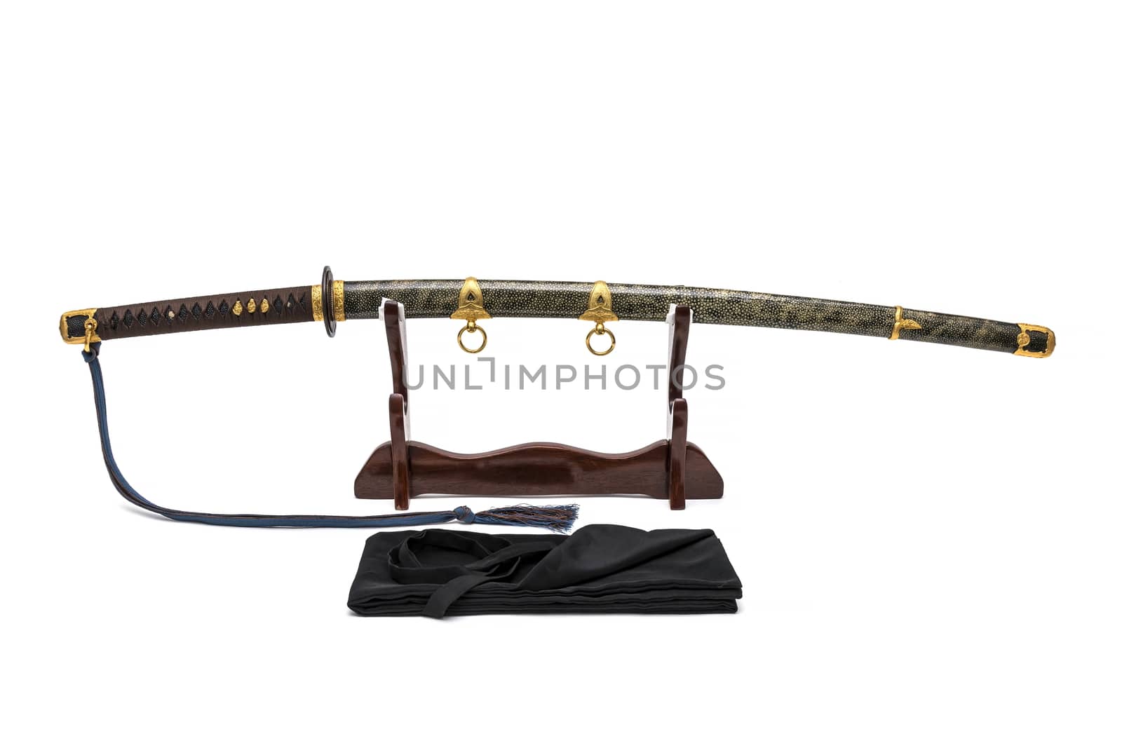 'Kai Gunto' : Japanese Marine Sword From World War 2 with scabbard wrapped by ray skin on wooden stand and bag in front of, isolated in white background.