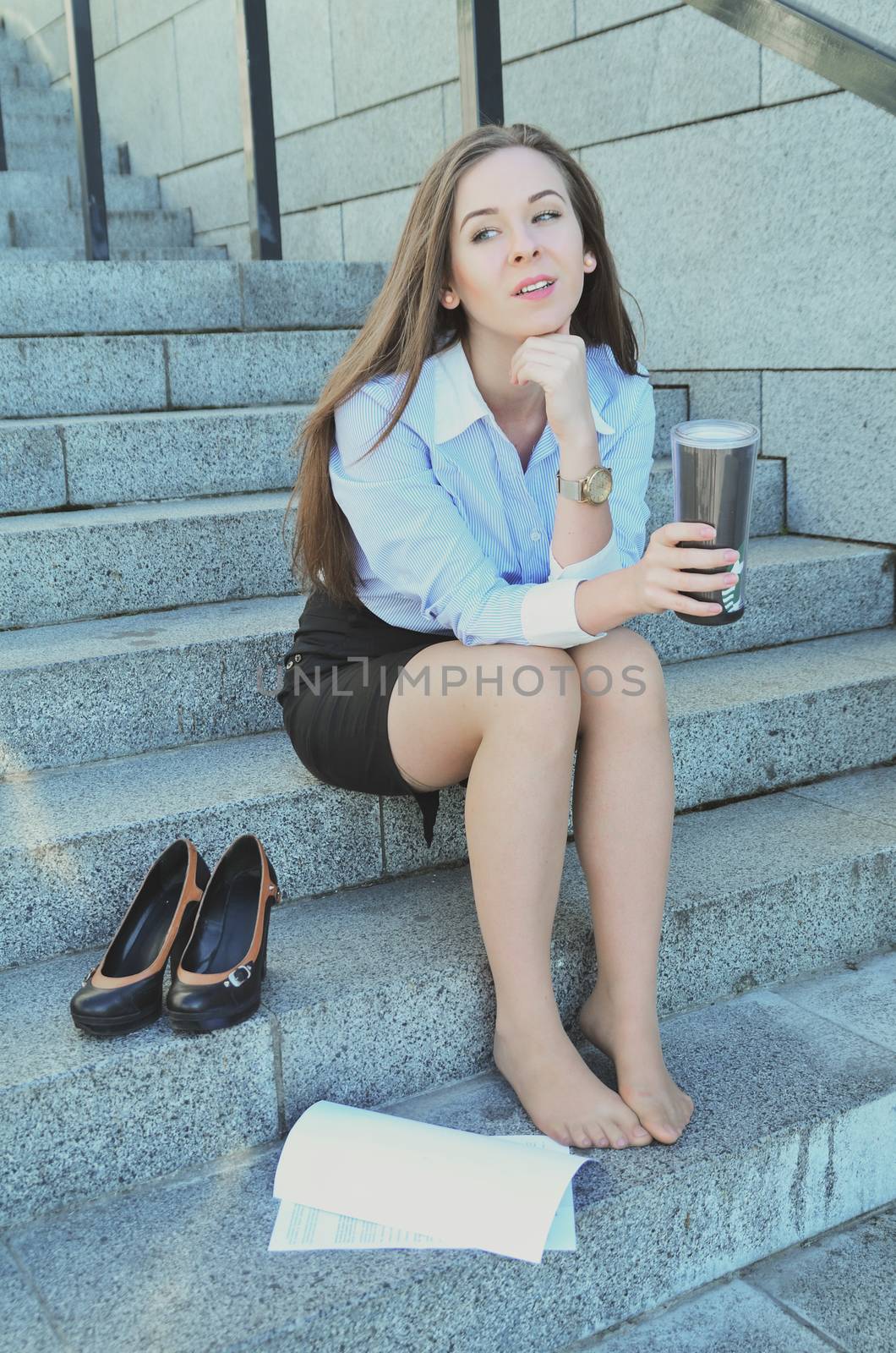 Business woman, during the break, sat down on the steps to think about fun, after a hard day's work