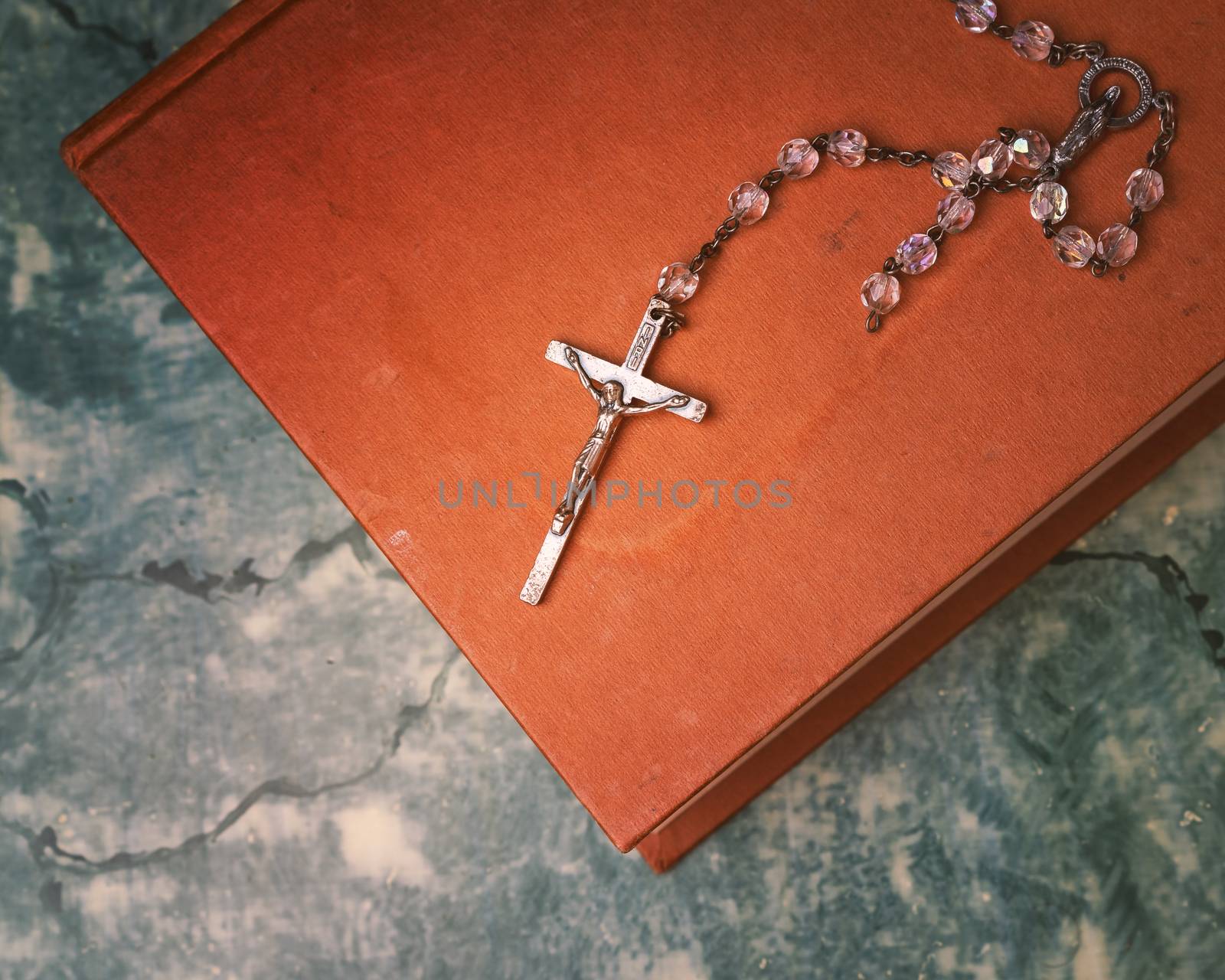 Rosary and cross resting on the closed book  by Robertobinetti70