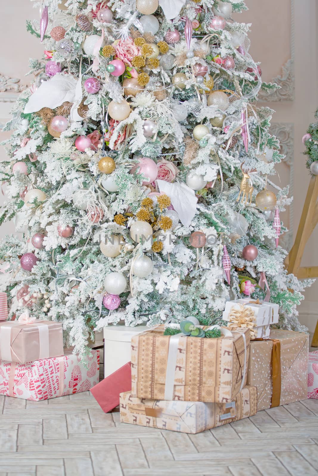 Decorated Christmas room with beautiful fir tree pink and beige pale colors