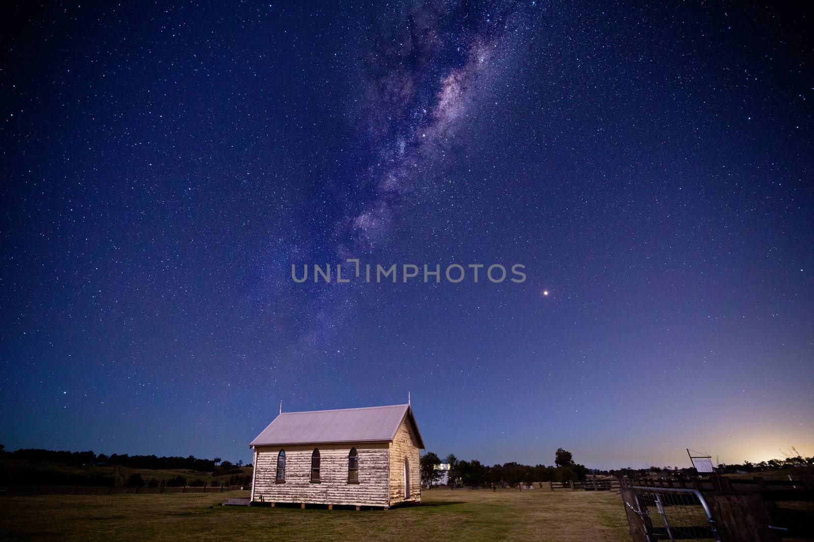 Mikly way universe starry sky over rustic old timber chapel and  rural field in Australia
