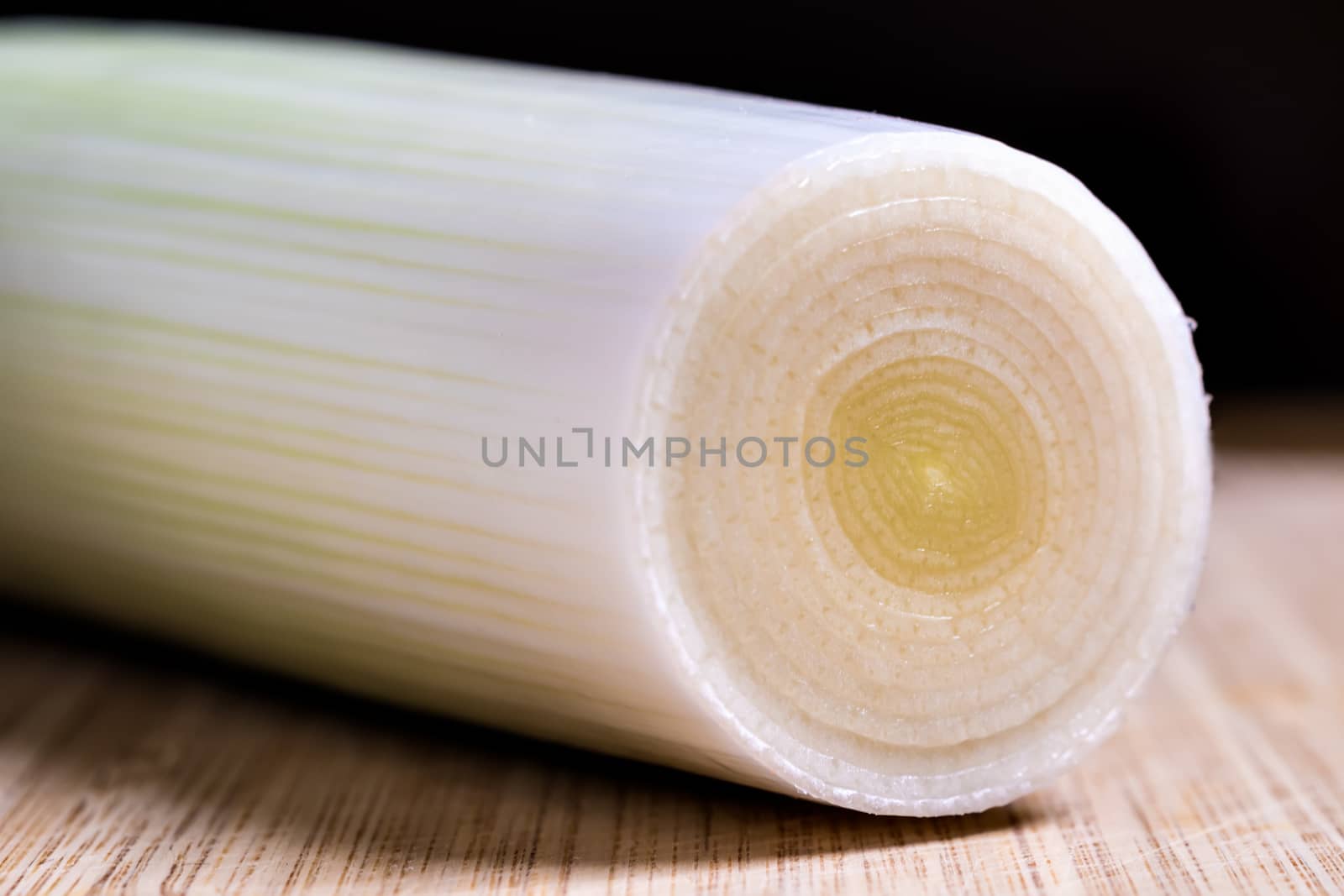 Closeup of white fresh sliced leek on a table with dark background