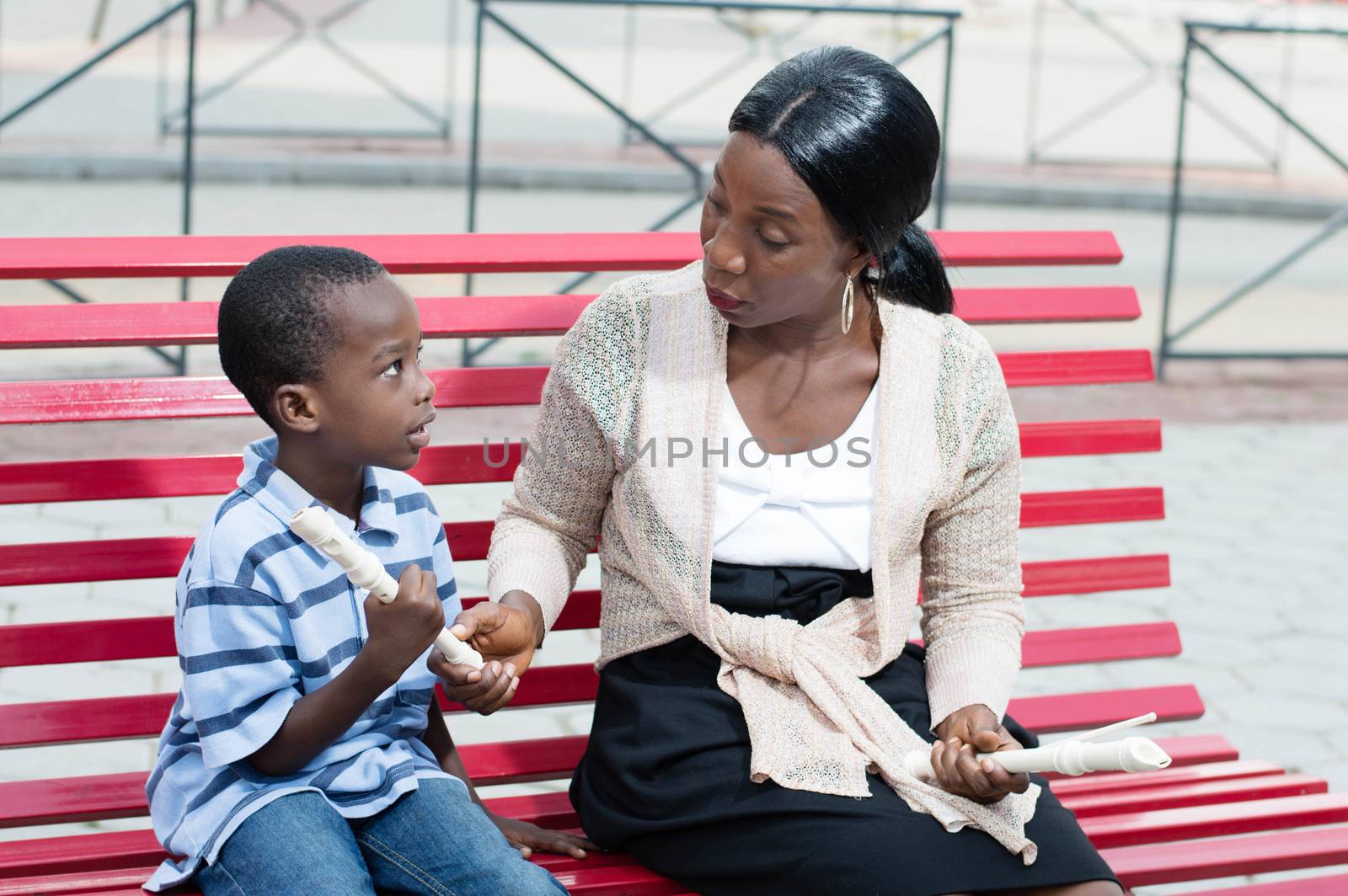 mother flute in hand teaches her son to music.