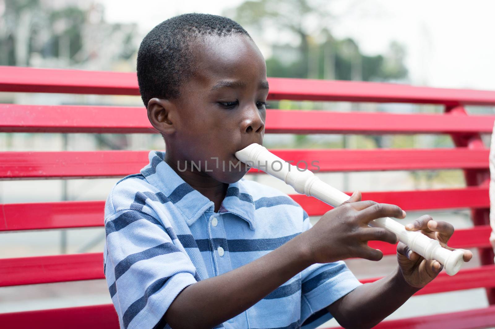 This child sitting on the bench trains on flute.