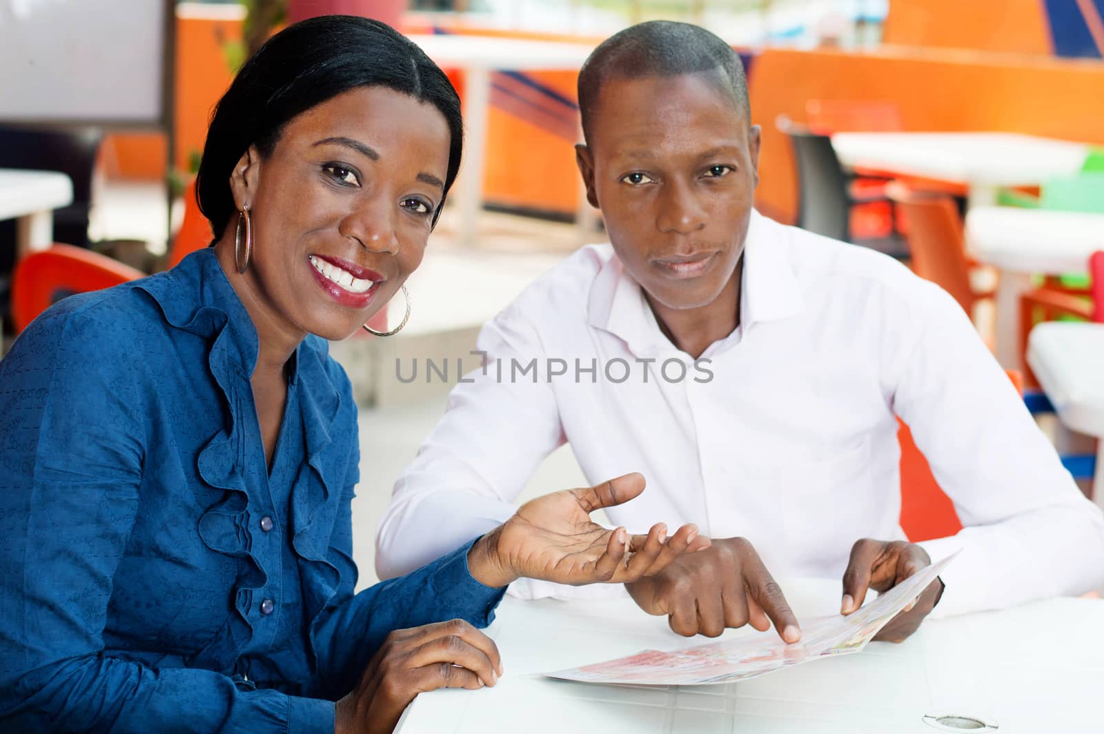couple smiling and sitting in the restaurant invite to make the choice.