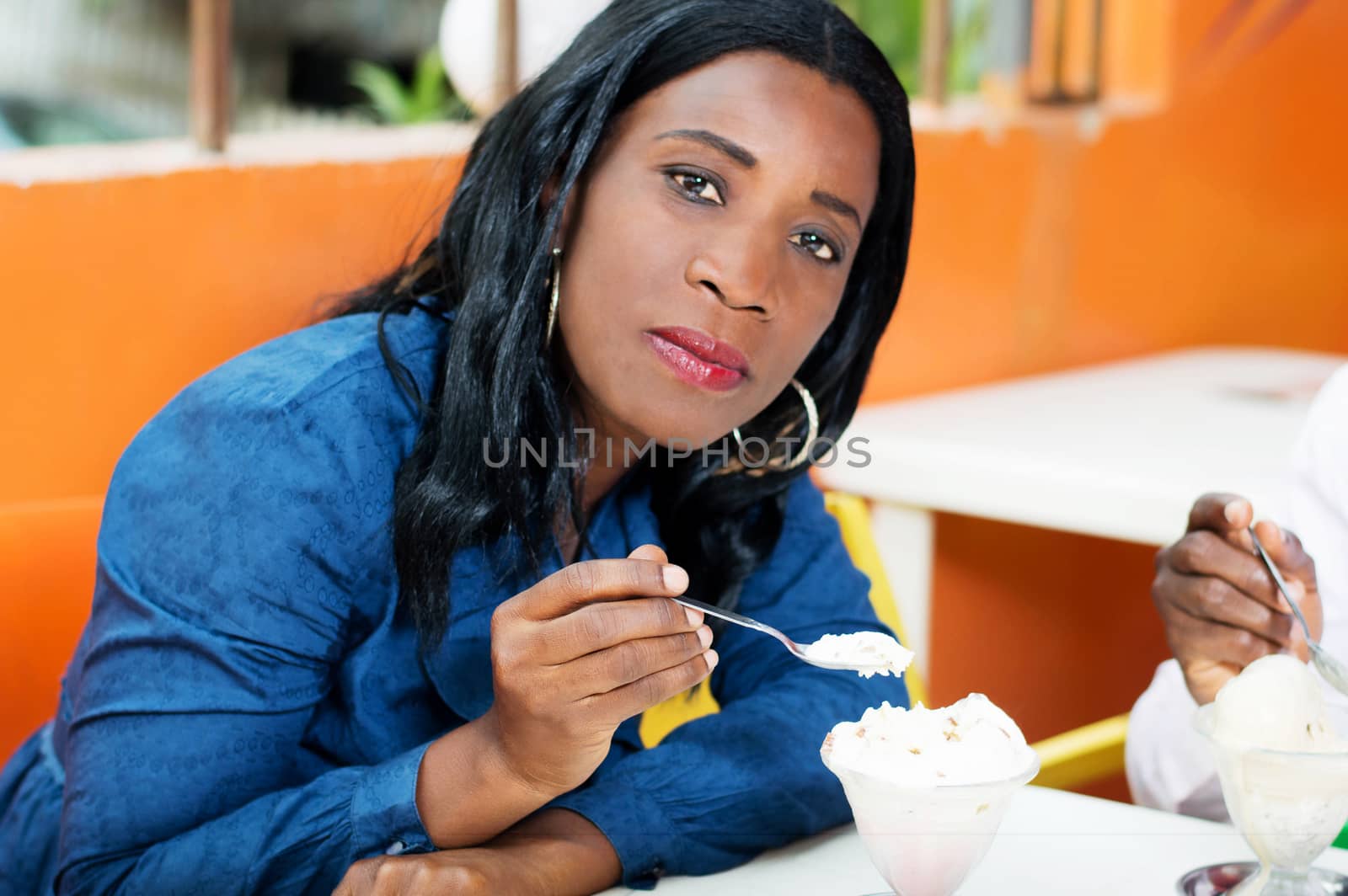 young woman eating a cream look at the camera.