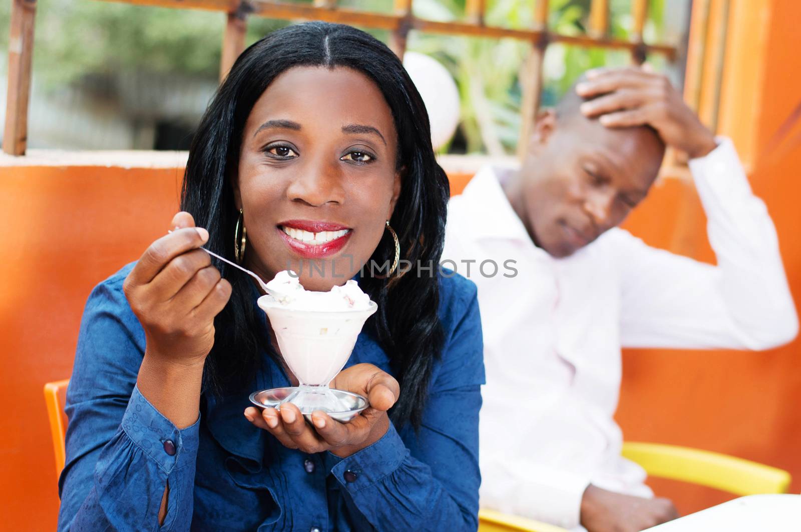smiling young woman holding in her hand a glass of ice and looking at the camera.