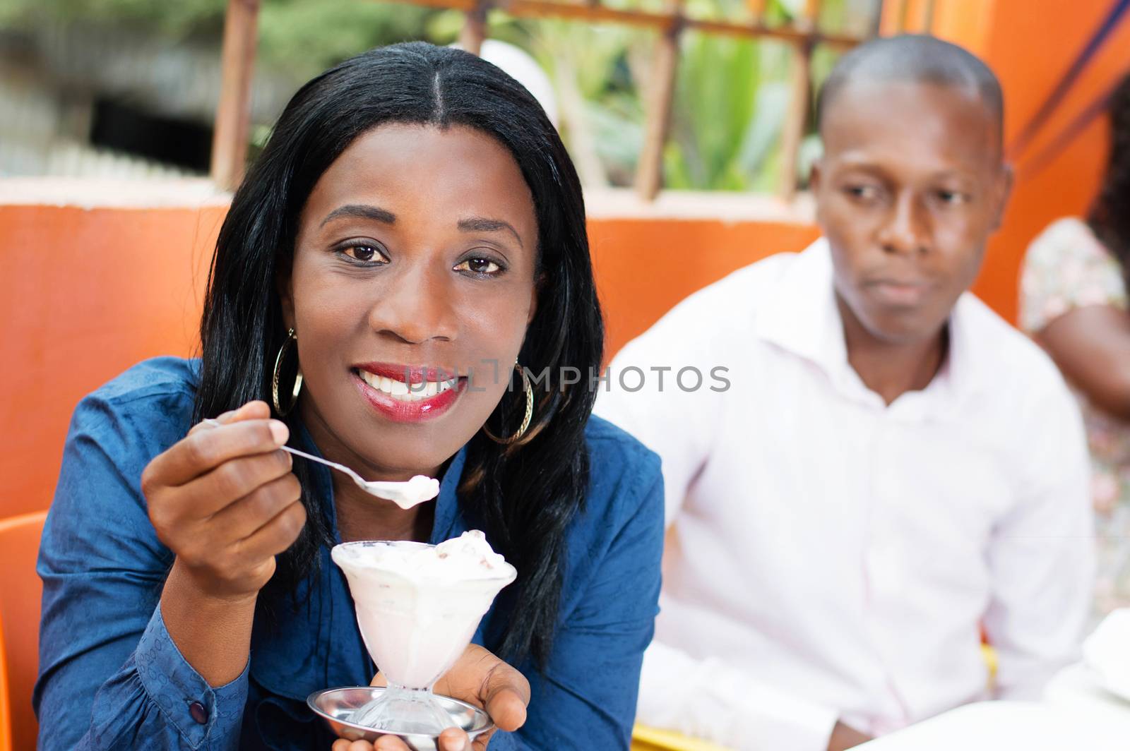 This young woman with an ice cream in hand, seems to be very happy . And a young man looks from behind.