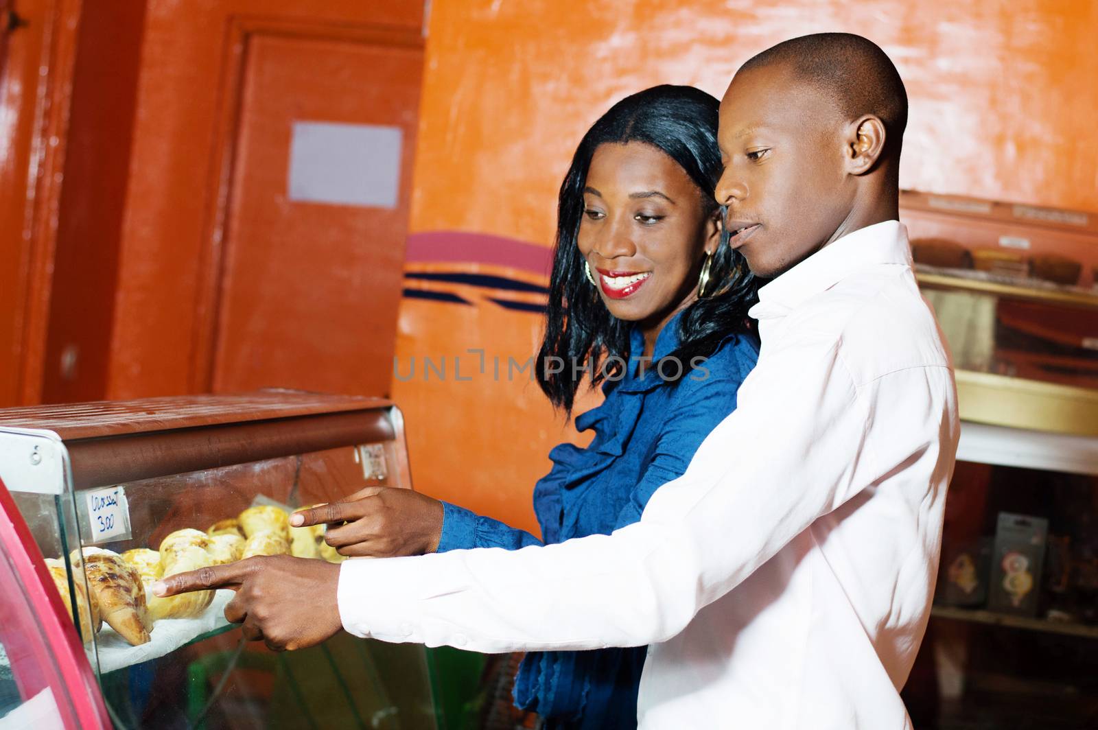 young smiling couple is now choosing cakes in a bakery for their breakfast.