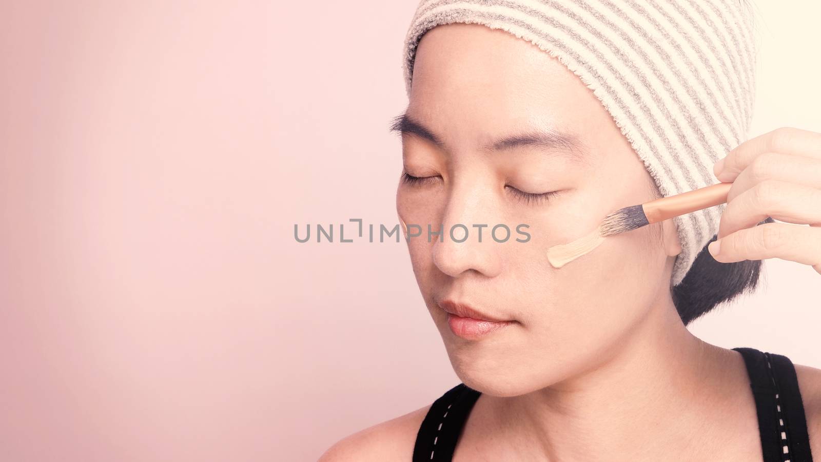 Asian girl making up by foundation liquid real no retouch by gnepphoto