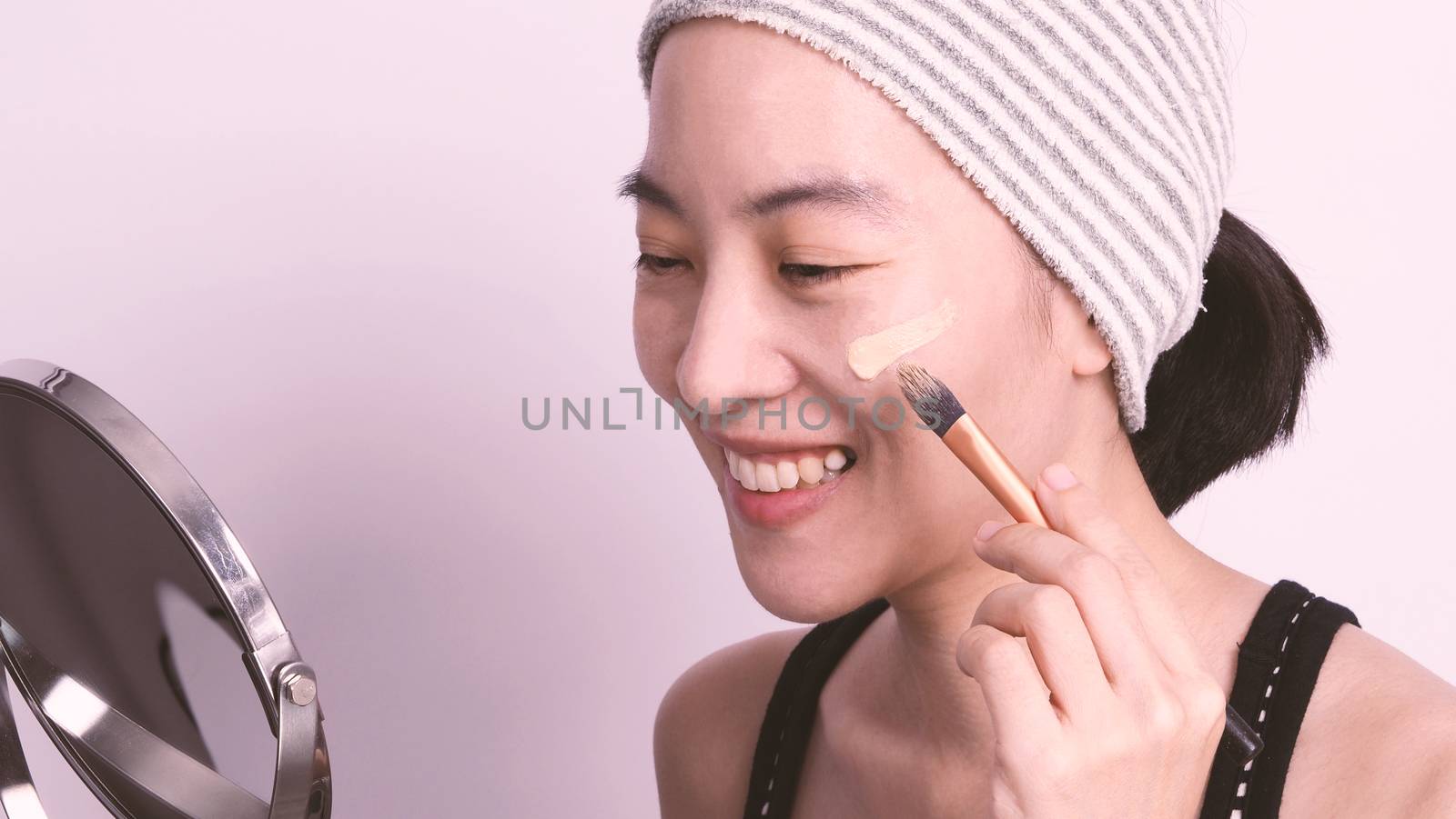 Asian girl making up by foundation liquid real no retouch by gnepphoto