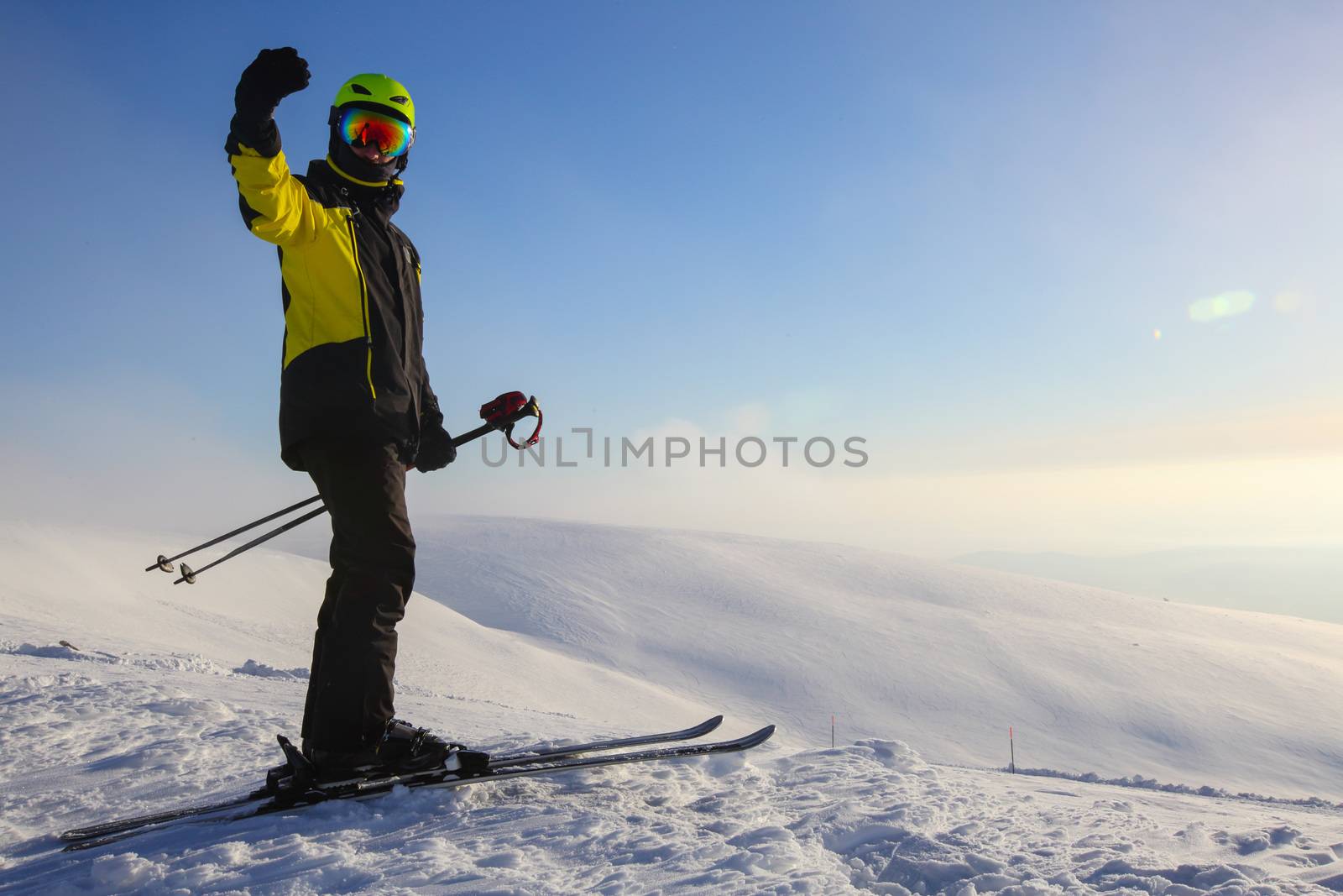 Skier on ski slope with mountains in background