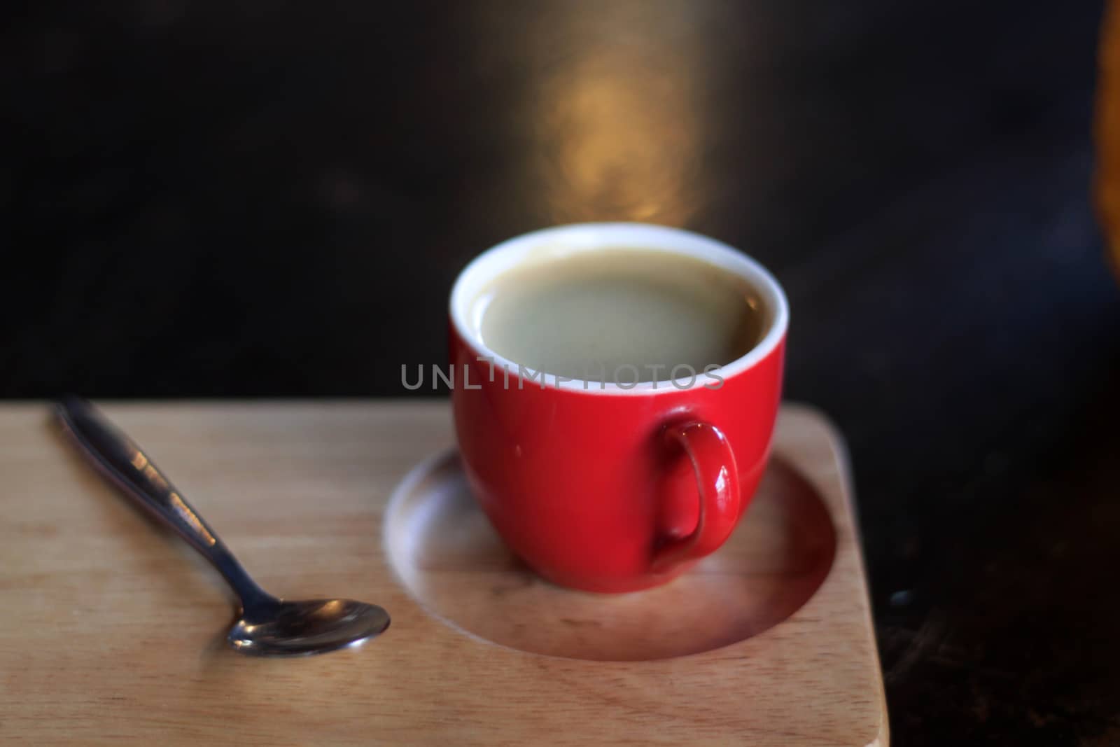 Red cup of coffee on wooden tray