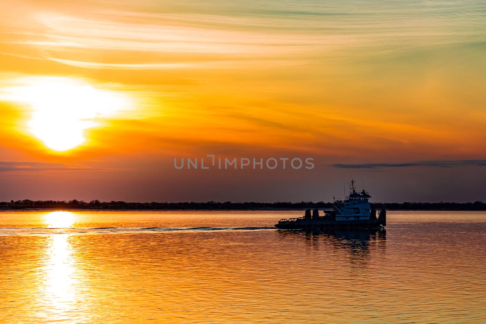 Sunset on the embankment of the Amur river in Khabarovsk. The sun set over the horizon. The embankment is lit by lanterns.