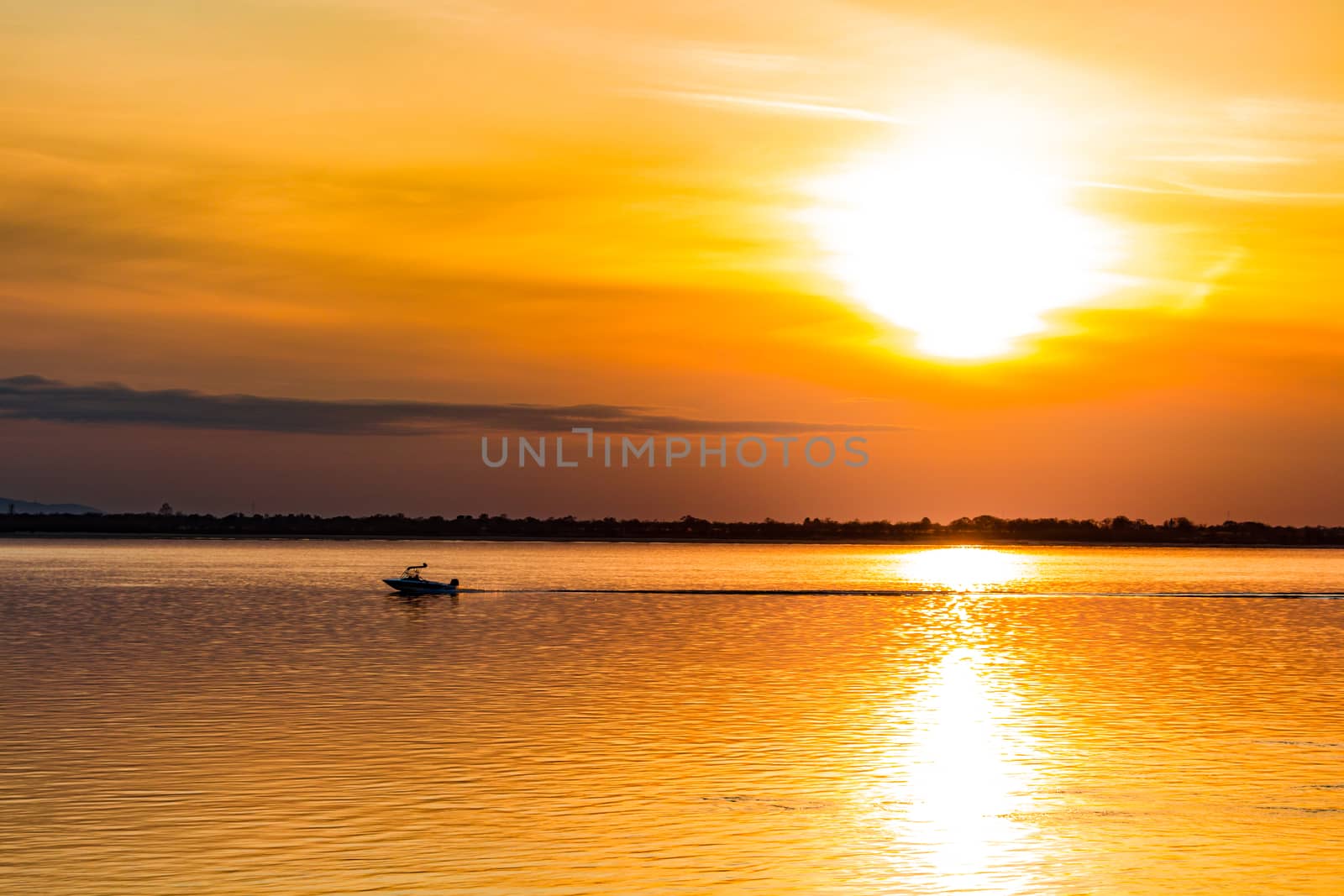 Sunset on the embankment of the Amur river in Khabarovsk. The sun set over the horizon. The embankment is lit by lanterns.