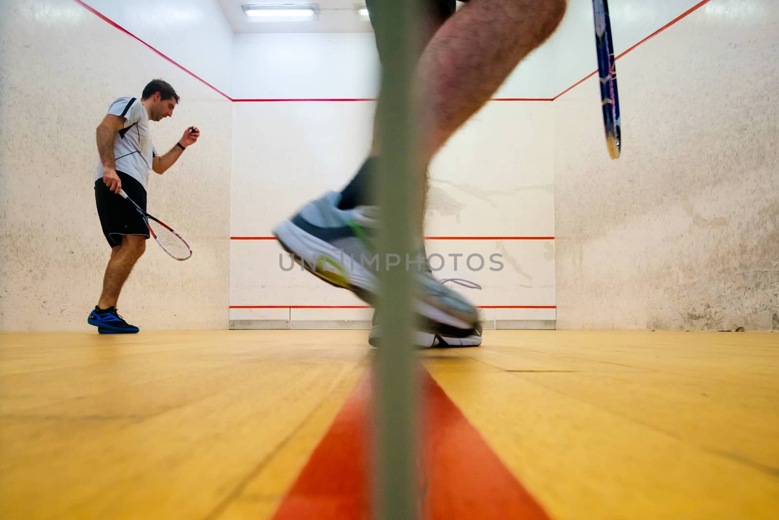Two friends playing squash in Mutilva, Navarra, Spain by mikelju