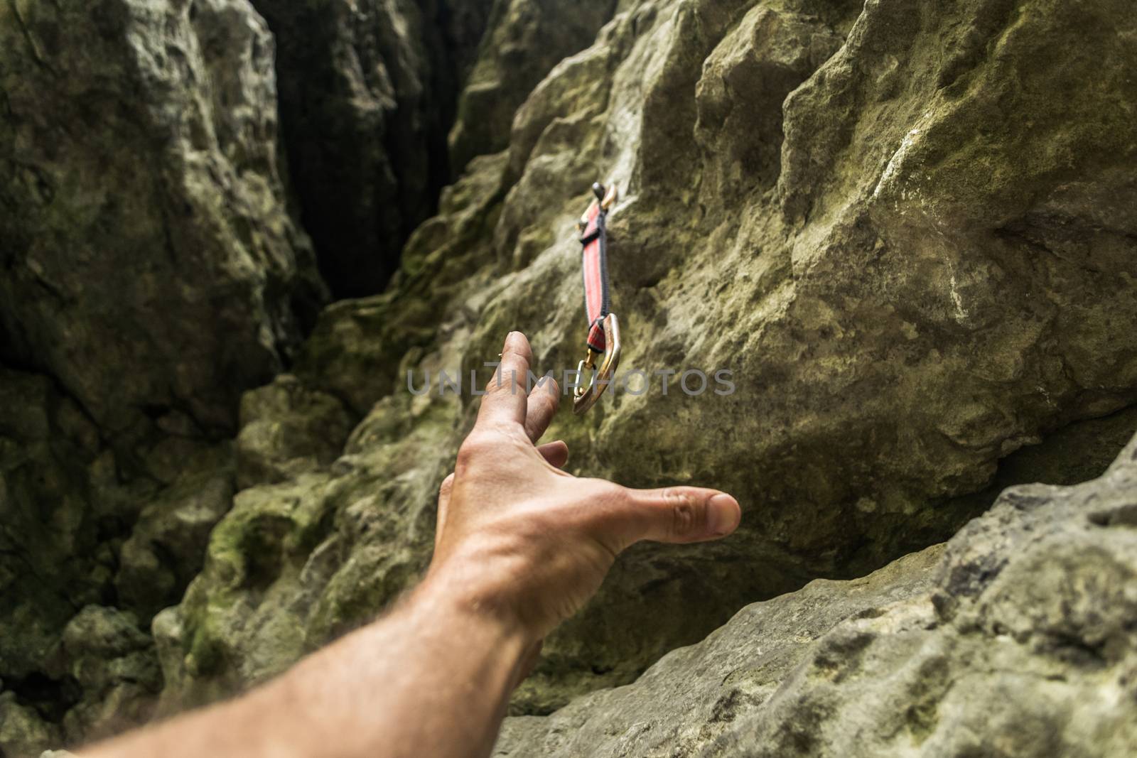 The climber's hand reaches the carbine. Rock climbing